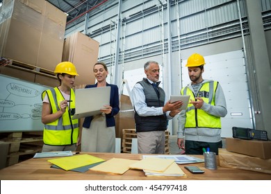 Warehouse Team Working On Laptop And Digital Tablet In Warehouse