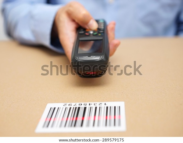 warehouse technician inspects stocks in storage\
with bar code reader