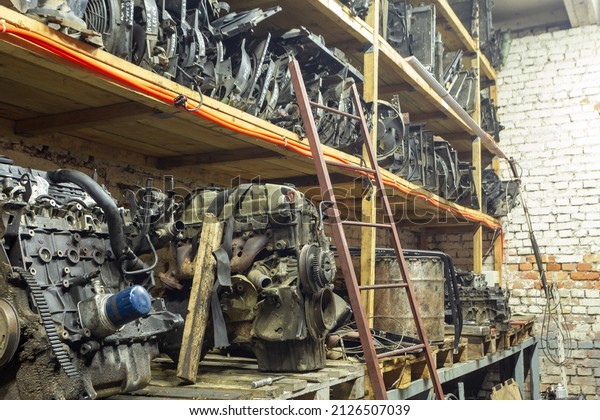 Warehouse\
with used auto parts for sale. Radiators of the cooling system and\
engines on the shelves of the warehouse. Trade in used spare parts\
is a common business in developing\
countries.