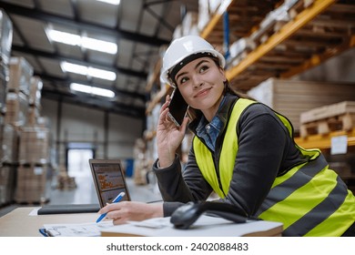Warehouse worker checking delivery, stock in warehouse on computer, pc, while phone calling with contractor. Warehouse manager using warehouse management software, app. - Powered by Shutterstock