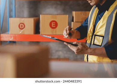 Warehouse worker checking inventory with clipboard in storage area. Logistics and supply chain management concept. - Powered by Shutterstock