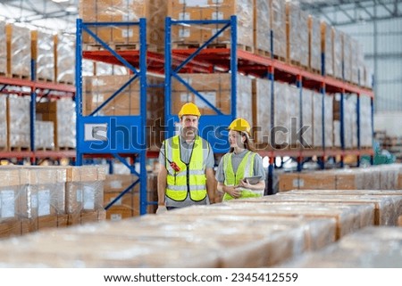 Warehouse worker checking the inventory in a large distribution warehouse.