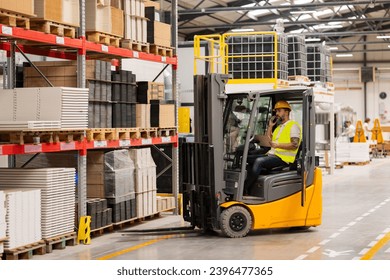 Warehouse worker driving forklift. Warehouse worker preparing products for shipmennt, delivery, checking stock in warehouse, order picking. - Powered by Shutterstock