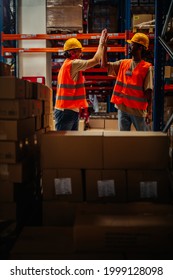 Warehouse Worker Giving High Five To His Friend Colleague. Workers Hands Touching And Clapping For Successfully Done Job In Warehouse.