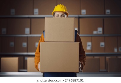 Warehouse worker holding delivery boxes and looking at camera, copy space - Powered by Shutterstock