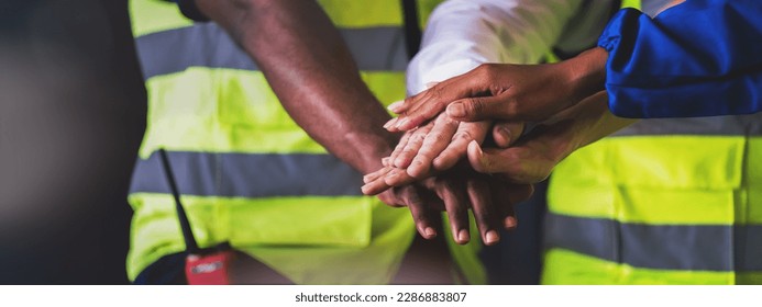 Warehouse worker joint hand together to making teamwork, Cooperation in factory with engineers and technician stacking hands to work together on big industrial project. - Powered by Shutterstock