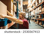 Warehouse worker lifting heavy box on storage shelf