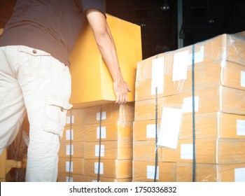 Warehouse Worker Lifting Shipment Boxes, Cartons, Cardboard Box, Warehouse Delivery Service Shipping Goods At Manufacturing Warehouse.