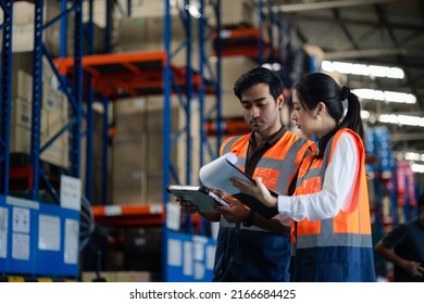 Warehouse Worker And Manager Checks Stock And Inventory With Digital Tablet Computer In The Retail Warehouse Full Of Shelves With Goods. Working In Logistics, Distribution Center.