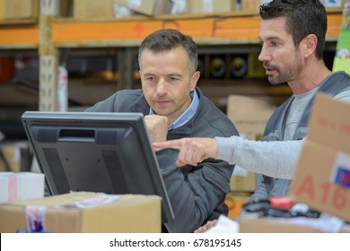 Warehouse Worker And Manager Using Computer In A Warehouse