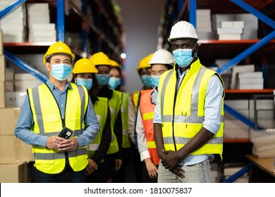 Warehouse worker in protective medical face mask working at large warehouse.  Many employees are working intently in the warehouse. Diversity peoples at work. - Shutterstock ID 1810075837