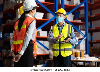 Warehouse Worker In Protective Medical Face Mask Working At Large Warehouse.  Many Employees Are Working Intently In The Warehouse. Diversity Peoples At Work.