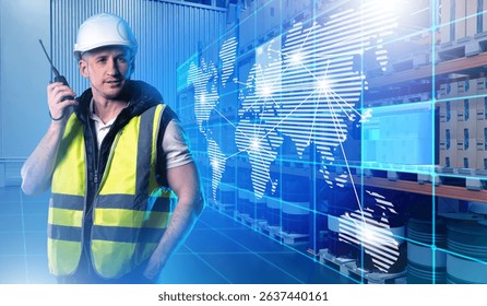 Warehouse worker with a radio in a smart logistics hub featuring a digital world map overlay, representing global supply chain connectivity and coordination.