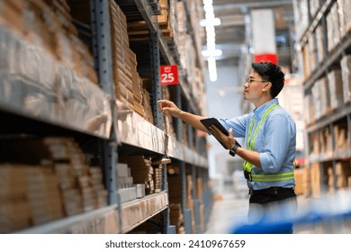 Warehouse worker in security uniform with tablet computer looking at merchandise in large warehouse Logistics and export business Logistics distribution center.