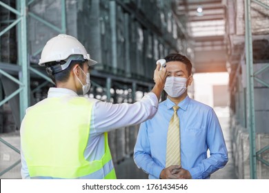 Warehouse Worker Staff Use An Infrared Thermometer Equipment To Check The Temperature On The Forehead And Use Alcohol Gel To Screen The Patients Addicted To Covid Virus Before Entering The Warehouse