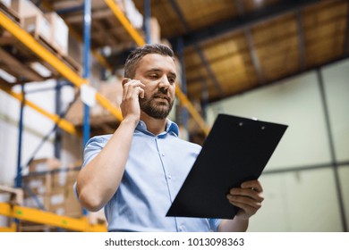 Warehouse Worker Or Supervisor With A Smartphone.