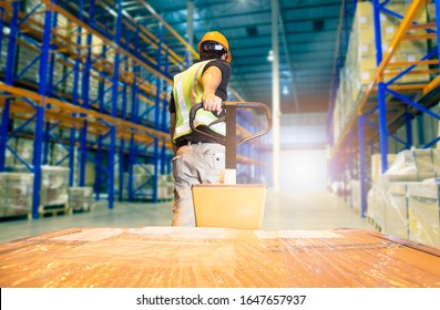 Warehouse worker unloading pallet shipment goods, Interior of storage warehouse,tall shelves storage of goods in warehousing 
