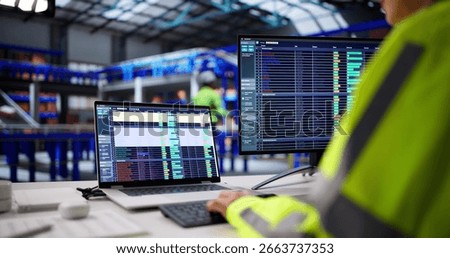 Warehouse Worker Uses Logistic Software To Manage Inventory And Orders. Woman In Business Office Monitors Spreadsheets