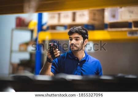 warehouse worker using bar code scanner to analyze newly arrived goods for further placement in storage department, logistic working at warehouse.