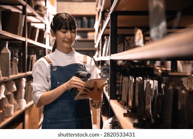 Warehouse worker using tablet and barcode scanner in storage aisle, smiling woman managing inventory in retail stockroom