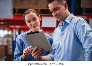 Warehouse worker working and checking the stock in the warehouse. Factory manager using digital tablet check barcode in industry factory logistic.