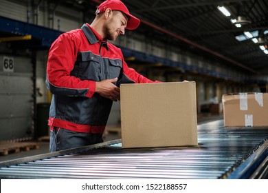 Warehouse worker working on a conveyor line - Shutterstock ID 1522188557