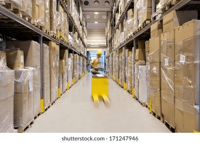 Warehouse worker with a yellow hand pallet truck