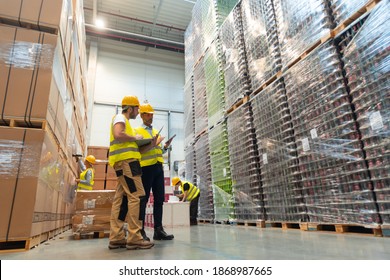 Warehouse workers consult delivery plans using laptop and electronic database - Powered by Shutterstock