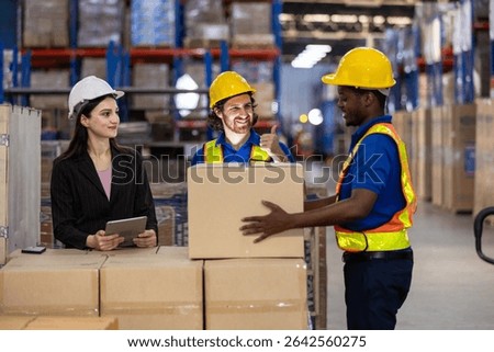 warehouse, workers are engaged in a discussion while employee prepares to lift a box. Active environment focused on logistics and teamwork.