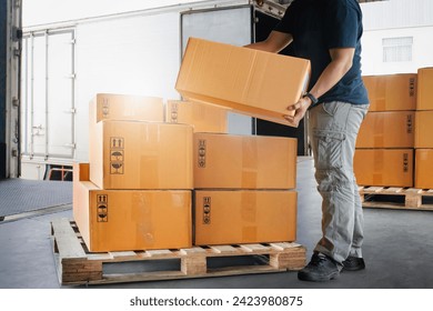 Warehouse Workers Lifting Package Boxes Stack on Pallet. Cartons, Cardboard Boxes. Supply Chain, Shipment Boxes,  Supplies Warehouse Shipping. Logistics Warehouse.	 - Powered by Shutterstock