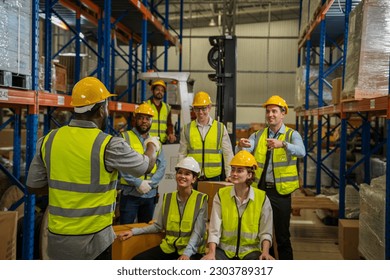 Warehouse workers are meeting together,Group of multicultural logistics employees working as a team in in a large distribution warehouse. - Powered by Shutterstock