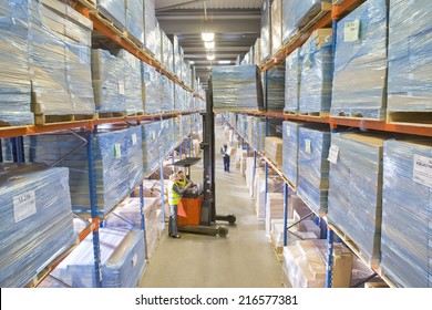 Warehouse workers moving boxes from shelf with forklift - Powered by Shutterstock