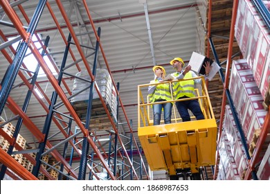 Warehouse workers on the height using lift work platform to check inventory