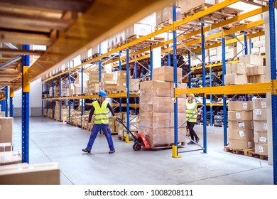 Warehouse workers pulling a pallet truck. - Shutterstock ID 1008208111