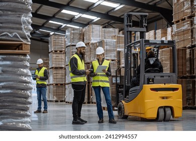 Warehouse workers reading product order, order picking. Warehouse manager checking delivery, stock in warehouse, inspecting products for shipment. - Powered by Shutterstock