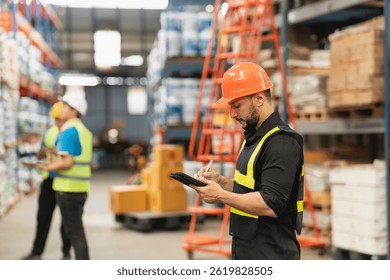 Warehouse Workers in Safety Gear Using Tablet for Inventory Management and Monitoring in Large Storage Facility