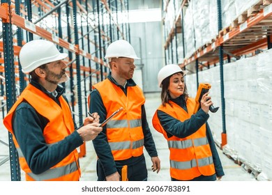 Warehouse workers utilizing barcode scanners and diligently taking notes during logistics operations for efficient inventory management