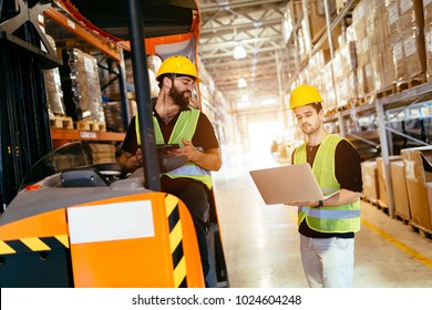 Warehouse Workers Working Together With Forklift Loader