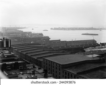 Warehouses line the Brooklyn shore of New York Harbor. View south includes Governor's Island in the mid-ground and Staten Island in the distance.Ca. 1912.