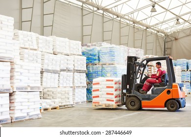 Warehousing. Forklift Driver Stacking Pallets With Cement Packs By Stacker Loader