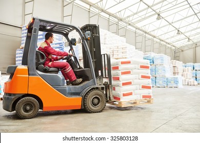warehousing. Forklift driver stacking pallets with cement packs by stacker loader