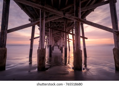 a warm autumn sun sets over a california coast pier. Memories of summer and play