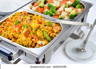 Warm Buffet With Spanish Paella And Mixed Buttered Vegetables Served In A Chafing Dish 