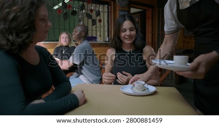Warm cafe interaction where coffee arrives at table, hands meet briefly, signaling care, service, and beginning of relaxed conversation between close friends ok now