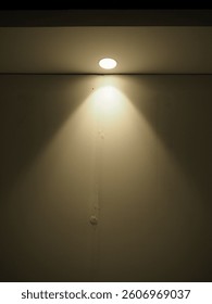 Warm Ceiling Light Casting Shadow on Wall
