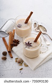 Warm chai tea with milk and winter spices in glass mugs