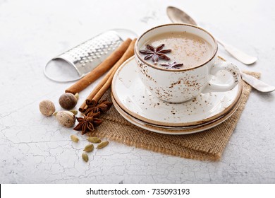 Warm chai tea with milk and winter spices in a ceramic cup