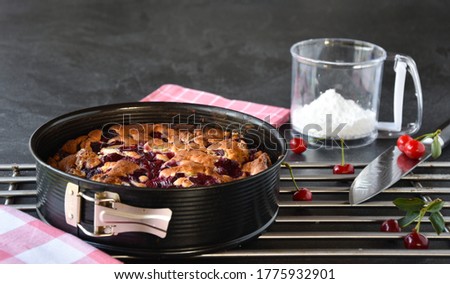 warm cherry cake in the springform pan on a wire rack