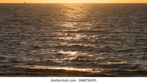 Warm Colors Of The Sunset Light Reflectet On The Water Rippled Surface Of The Ocean