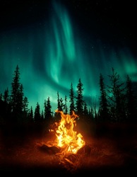 A Warm And Cosy Campfire In The Wilderness With Forest Trees Silhouetted In The Background And The Stars And Northern Lights -Aurora Borealis- Lighting Up The Night Sky. Photo Composite.